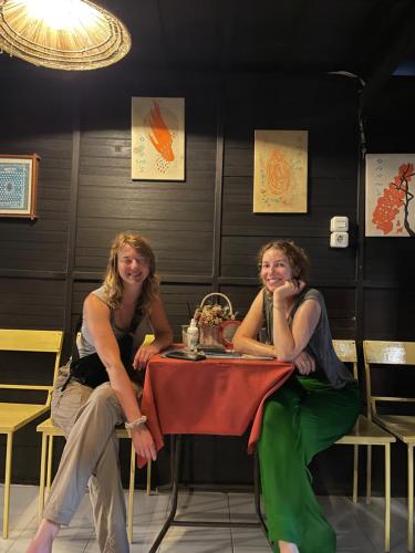 two women sitting at a table in a restaurant at Lego Lego Bulubarakka homestay and cafe in Kasijala