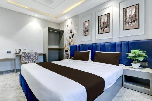 a bedroom with a large bed with a blue wall at Super Townhouse Haridwar Vishwakarma Ghat Formerly Haridwar Aagman in Haridwār