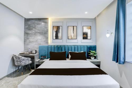 a bedroom with a large bed with a blue headboard at Super Townhouse Haridwar Vishwakarma Ghat Formerly Haridwar Aagman in Haridwār