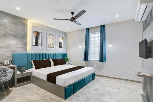a bedroom with a large bed and a ceiling fan at Super Townhouse Haridwar Vishwakarma Ghat Formerly Haridwar Aagman in Haridwār