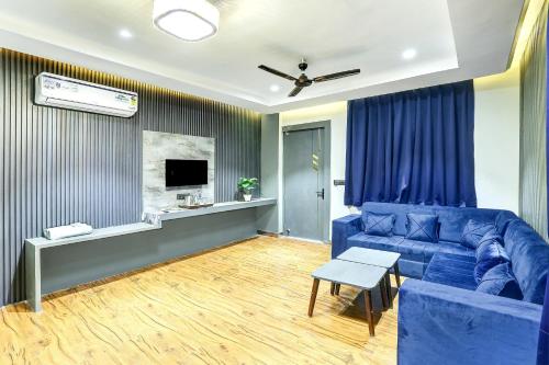 a living room with a blue couch and a tv at Super Townhouse Haridwar Vishwakarma Ghat Formerly Haridwar Aagman in Haridwār