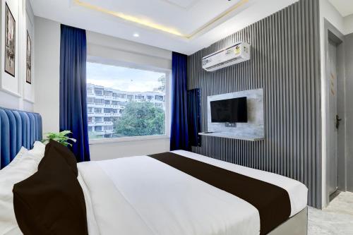 a bedroom with a large bed and a window at Super Townhouse Haridwar Vishwakarma Ghat Formerly Haridwar Aagman in Haridwār