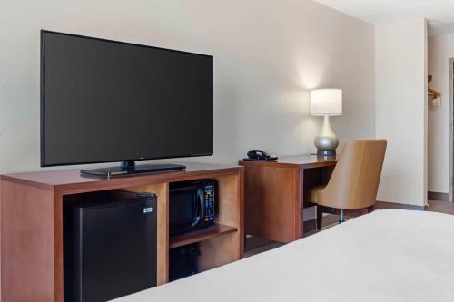 a room with a flat screen tv on a entertainment center at Comfort Inn & Suites Orlando North in Sanford