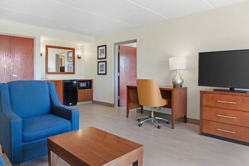a living room with a blue chair and a tv at Comfort Inn & Suites Orlando North in Sanford