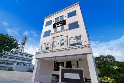 a tall white building with a sign on it at Super Townhouse Haridwar Vishwakarma Ghat Formerly Haridwar Aagman in Haridwār