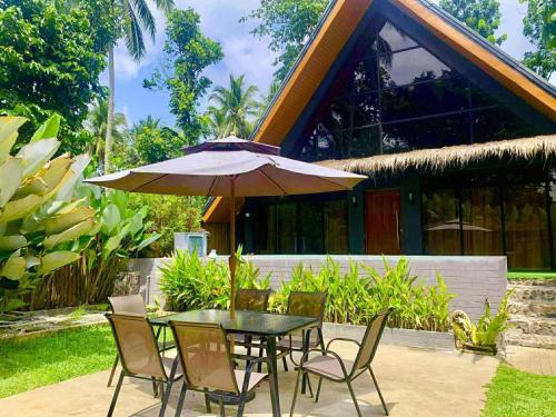 a table and chairs with an umbrella on a patio at The Bali Farm in Cabuyao