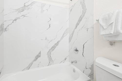 a white bathroom with a white toilet and a sink at MainStay Suites Raleigh North in Raleigh