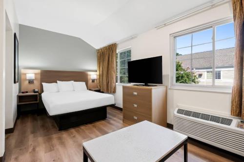 a hotel room with a bed and a window at MainStay Suites Raleigh North in Raleigh