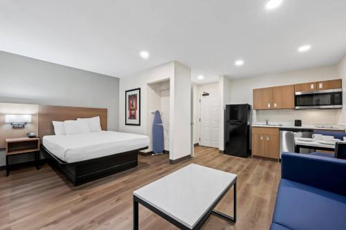 a hotel room with a bed and a kitchen at MainStay Suites Raleigh North in Raleigh