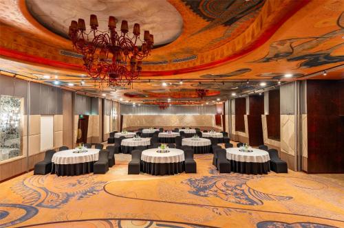a banquet hall with tables and a chandelier at Radisson Blu Hotel MBD Ludhiana in Ludhiana