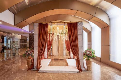 a lobby with a large doorway with curtains and flowers at Radisson Blu Hotel MBD Ludhiana in Ludhiana