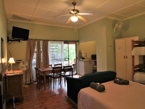 a living room with a bed and a dining room at Dempsey's Self-Catering Guest House in Port Elizabeth
