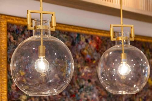 three clear glass bulbs hanging from a ceiling at Cambria Hotel Columbia Downtown the Vista in Columbia
