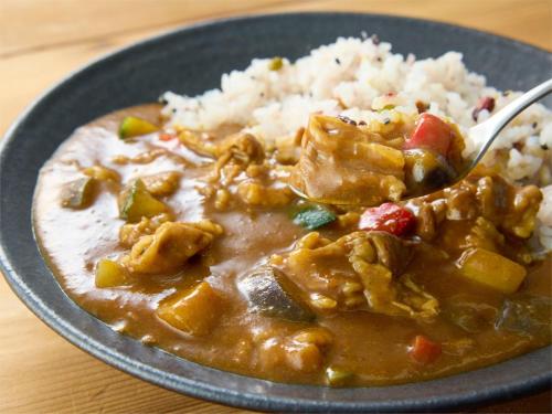 a bowl of curry and rice on a wooden table at Comfort Inn Kofu Isawa in Fuefuki