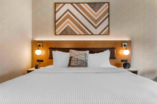 a bedroom with a large white bed with two lamps at Cambria Hotel Columbia Downtown the Vista in Columbia