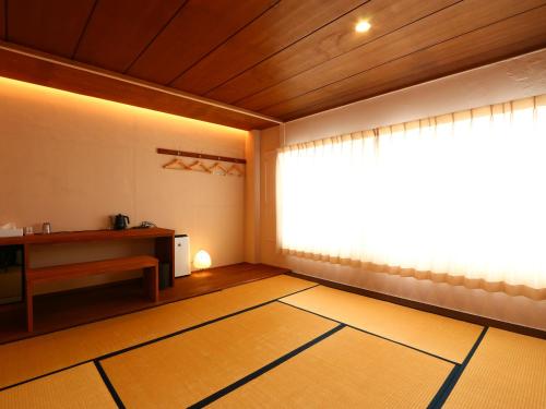 an empty room with a large window and a table at nirasakiyaSTAY in Nirasaki