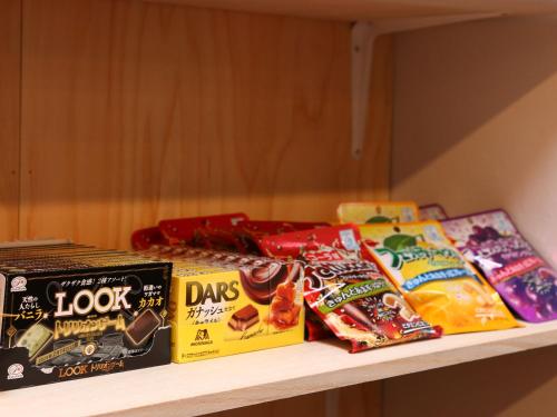a shelf with different types of snacks on it at nirasakiyaSTAY in Nirasaki