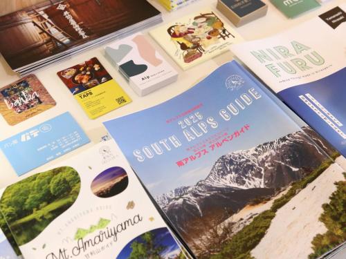 a table with brochures on it with mountains at nirasakiyaSTAY in Nirasaki