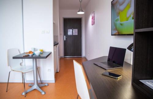 a table with a laptop computer on top of it at Comfort Aparthotel Besancon Hauts du Chazal in Besançon