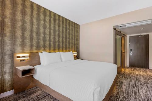 a bedroom with a large white bed and a wall at Cambria Hotel Portland - Pearl District in Portland