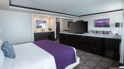a hotel room with a bed and a flat screen tv at Harrah's Gulf Coast, A Caesars Destination in Biloxi