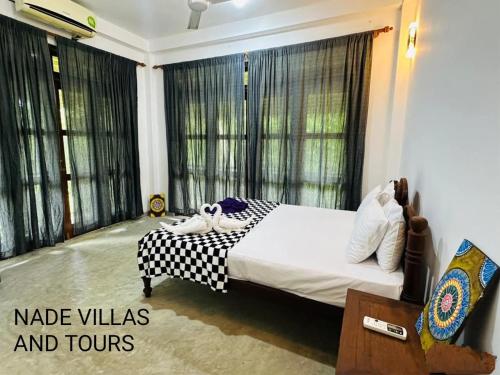a bedroom with a bed with black curtains and windows at Nade villas madu river wives in Balapitiya
