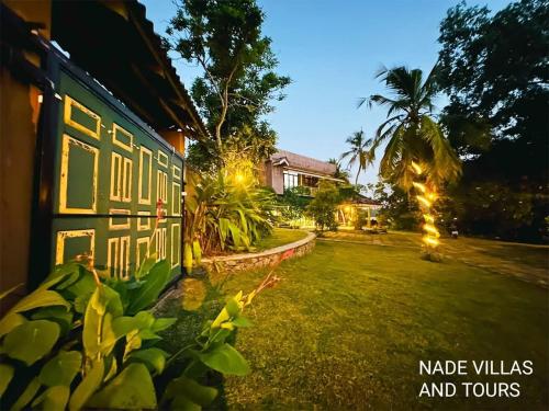 a yard with a house with lights on it at Nade villas madu river wives in Balapitiya