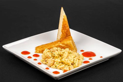 a white plate with a piece of toast and scrambled eggs at Cambria Hotel Portland - Pearl District in Portland