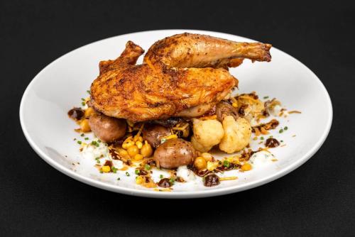 a white plate of food with chickens and potatoes at Cambria Hotel Portland - Pearl District in Portland