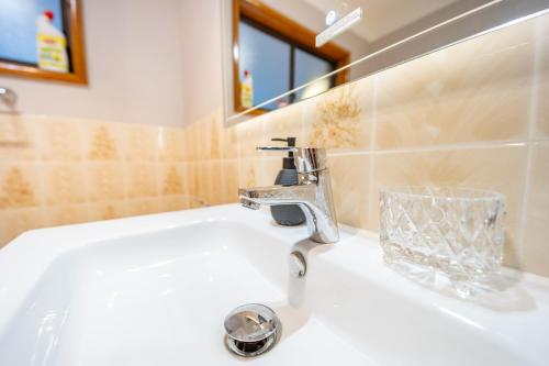 a bathroom sink with a faucet and a mirror at Serene Farmhouse with Lake Views in Burrawang