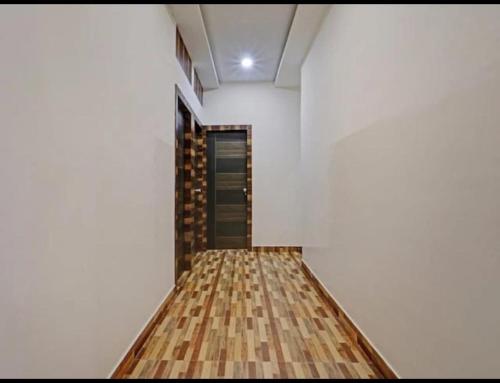 a room with white walls and a wooden floor at Hotel Dhruvas residency in Bengaluru