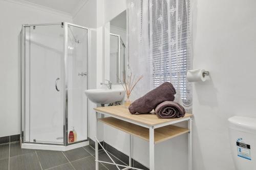 une salle de bain blanche avec lavabo et douche dans l'établissement HOBART 2 Bedroom, à West Hobart