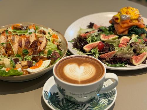 three plates of food and a cup of coffee on a table at WeLight逐光旅舍百花深处胡同店 in Beijing