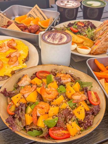 a table topped with plates of food with shrimp and vegetables at WeLight逐光旅舍百花深处胡同店 in Beijing