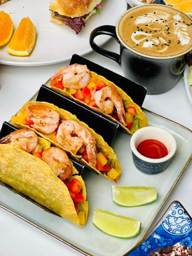 a plate of food with shrimp and vegetables and a cup of coffee at WeLight逐光旅舍百花深处胡同店 in Beijing