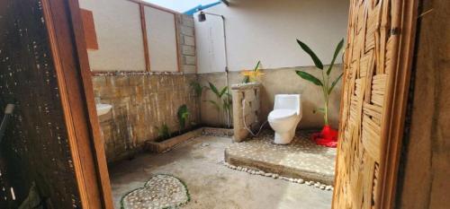 a small bathroom with a toilet and a sink at homestay noah in Likupang
