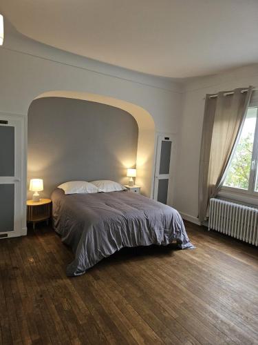 ブールジュにあるMaison Aéroport Bourgesの大きなベッドと大きな窓のある寝室