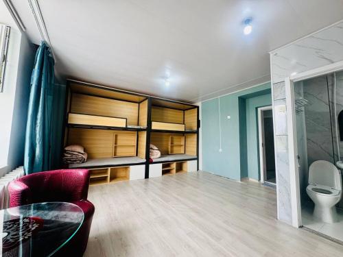 una camera da letto con letti a castello con un bagno e una sedia di Zuulun Hostel a Bulgan