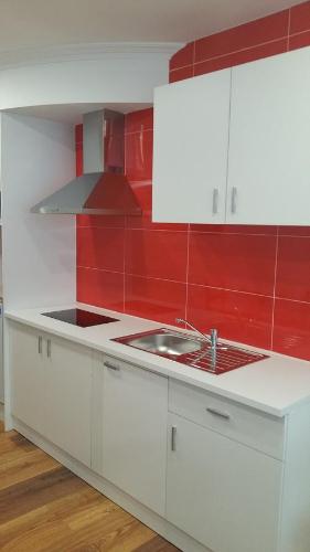 a kitchen with white cabinets and a sink at Fermont in Foz