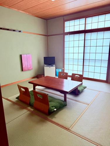 a room with a table and chairs in it at 民泊御座岬 Minpaku Gozamisaki in Goza