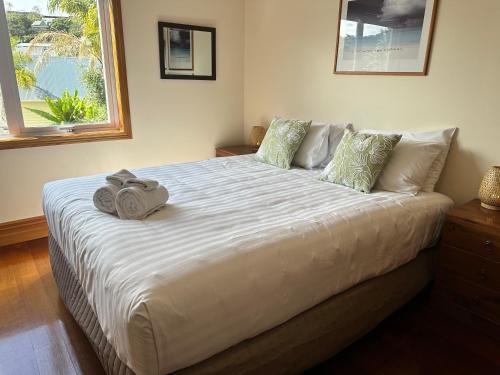 a bedroom with a large bed with two towels on it at Russell Harbour Apartment in Russell