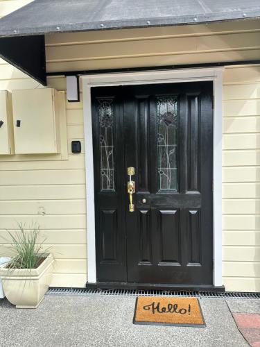 a black front door of a house with a welcome mat at Russell Harbour Apartment in Russell