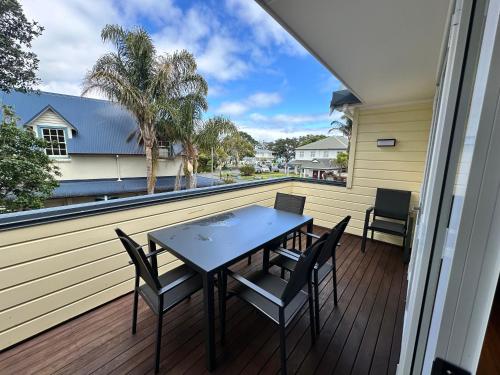 a patio with a table and chairs on a balcony at Russell Harbour Apartment in Russell
