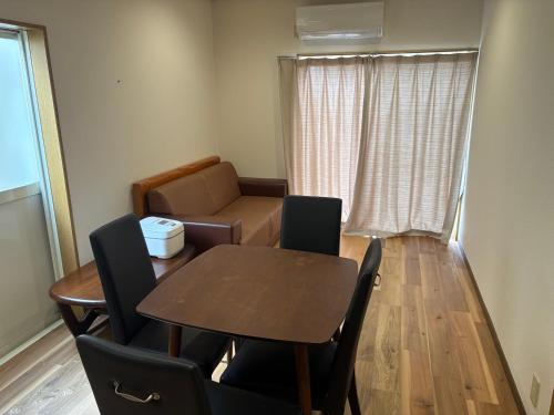 a living room with a table and a couch at 民泊御座岬 Minpaku Gozamisaki in Goza