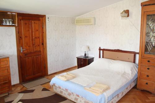 a bedroom with a bed and a dresser and a door at Hotel Queen in Mtskheta