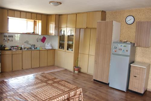 a kitchen with wooden cabinets and a white refrigerator at Hotel Queen in Mtskheta
