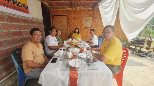a group of people sitting at a table at homestay noah in Likupang