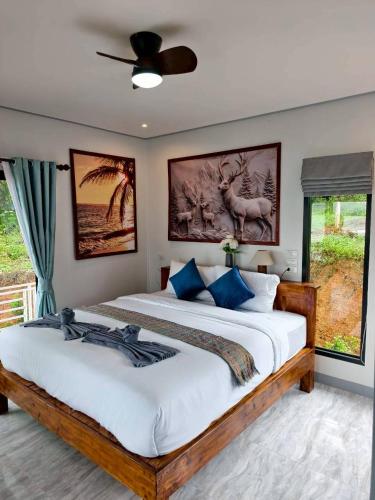 a bedroom with a large bed with blue pillows at Relax sunsmile Kohyaonoi in Ko Yao Noi