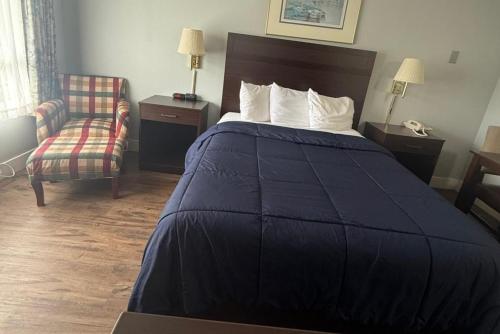 a hotel room with a bed and a chair at Coratel Inn Ocean Shores Extended Stay in Ocean Shores