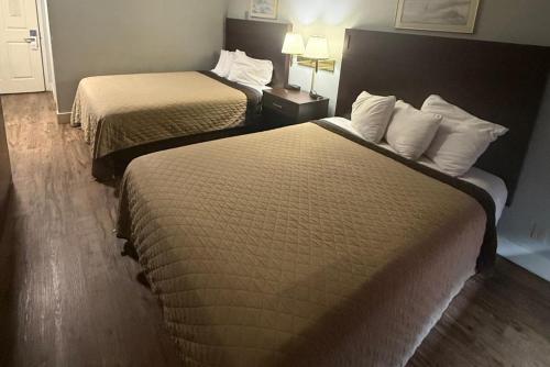 a hotel room with two beds and two lamps at Coratel Inn Ocean Shores Extended Stay in Ocean Shores